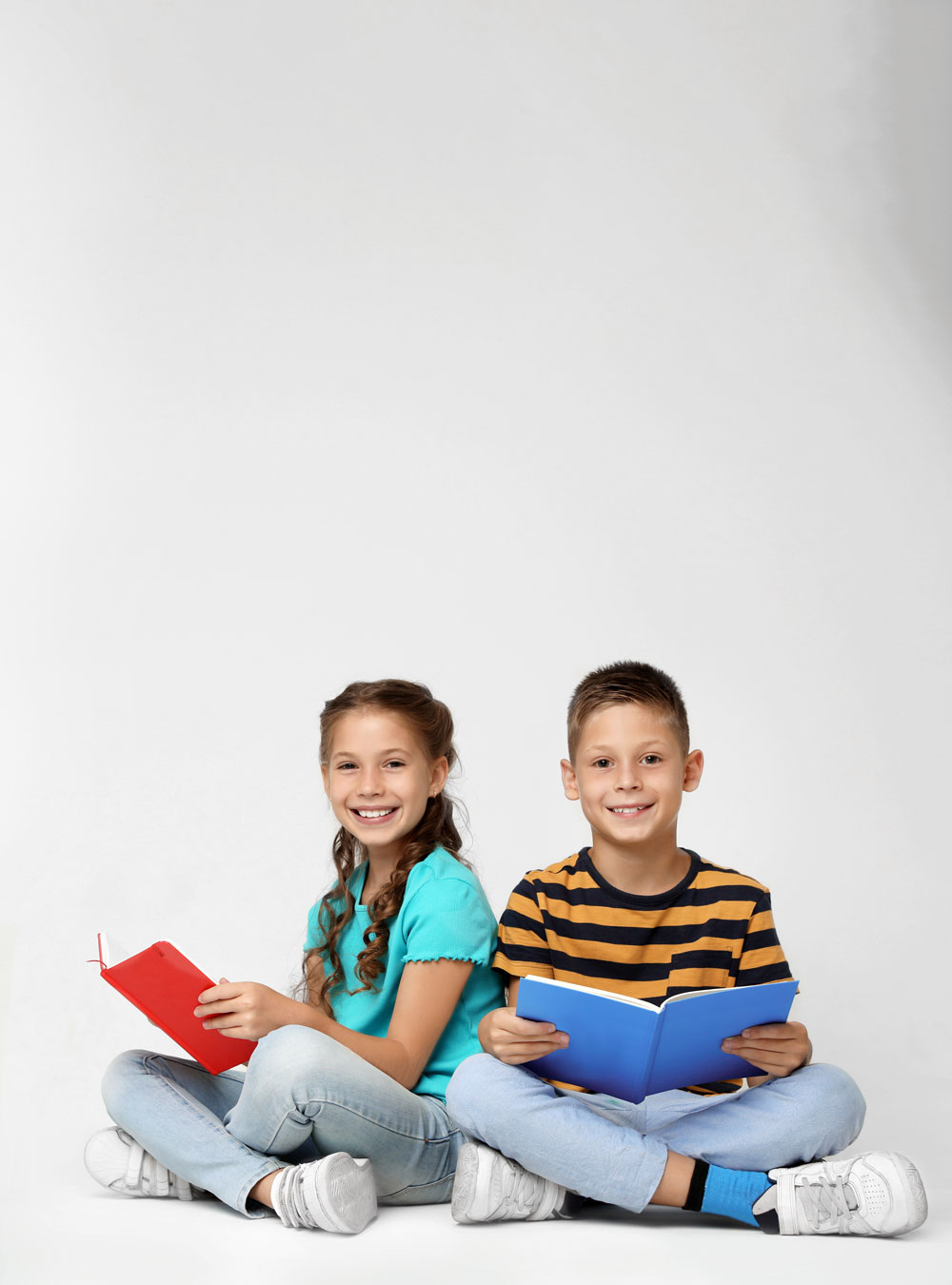 Two Kids are Sitting while Reading Books